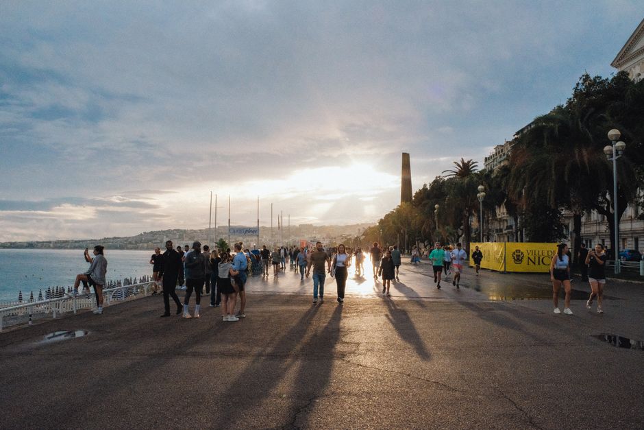 Wandelende silhouetten op de Promenade des Anglais tijdens zonsondergang