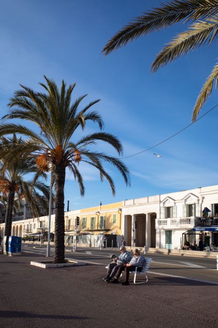Coppia che condivide una socca su una panchina soleggiata nel Vieux-Nice