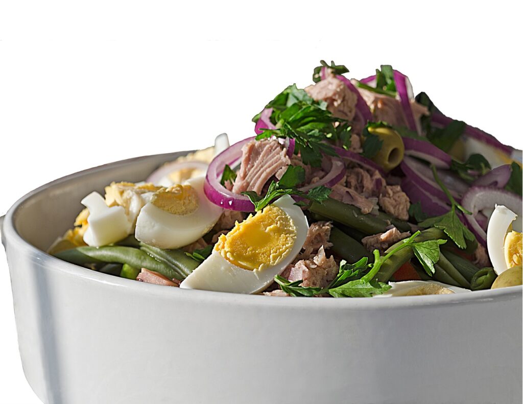 Frische Salade Niçoise angerichtet mit Eiern, Oliven und Thunfisch
