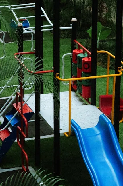 Kolorowy plac zabaw z niebieską zjeżdżalnią i drabinką