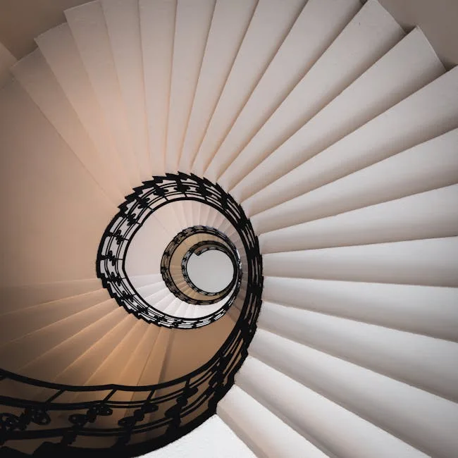 Spiralne schody wieżowe w Pizie z ozdobną metalową balustradą