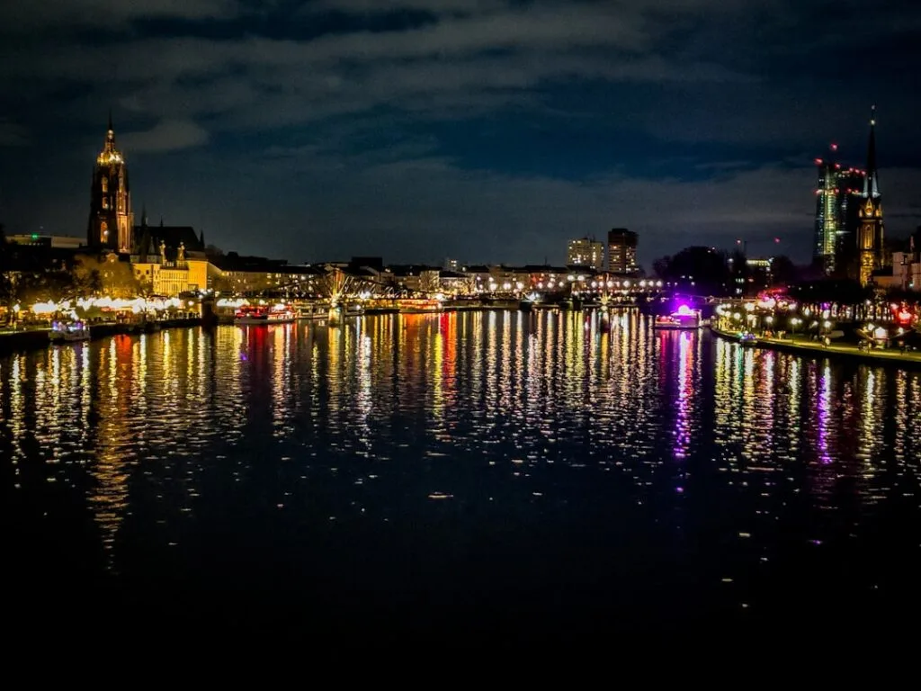 Kolorowe odbicia świateł na rzece przy nocnym bulwarze
