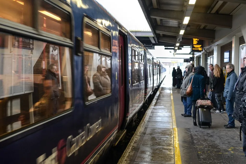 Voyageurs attendant un train sur un quai de gare animé