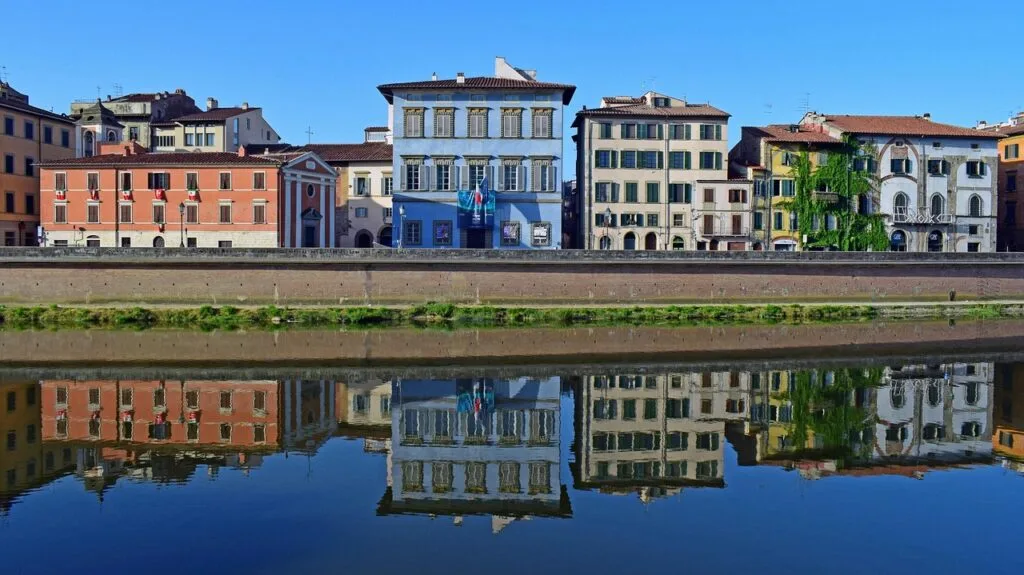 Façades colorées le long de l'Arno à Pise, reflet parfait dans l'eau