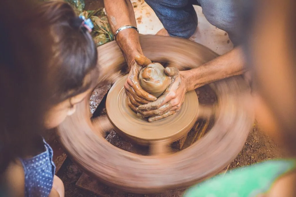 Artisan montrant le tournage d'argile à un enfant dans un atelier à Pise