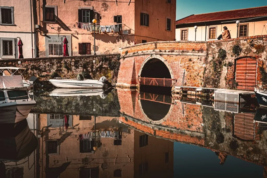 Pont en brique sur canal de Livourne, reflets et bateaux amarrés