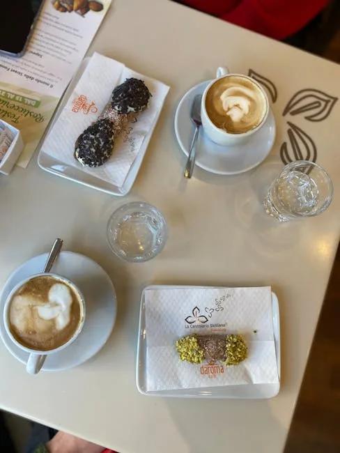 Dwa cappuccino i ciasteczko pistacjowe na stoliku kawiarnianym