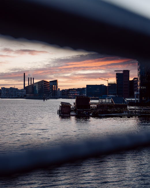 Copenhagen skyline over the harbor at sunset with reflective water and dining view