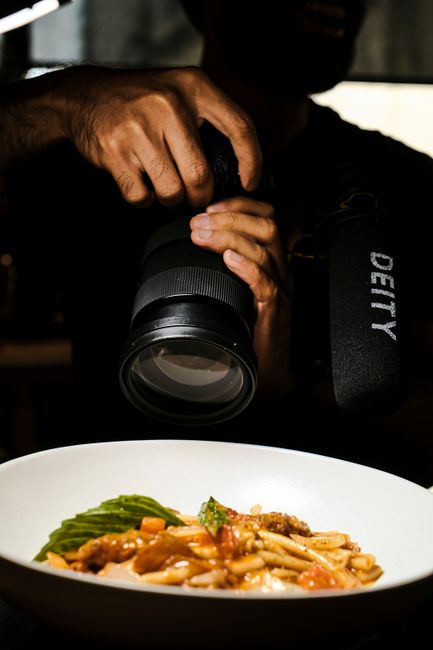 Hand holding camera photographing a plated Nordic dish in a Copenhagen restaurant