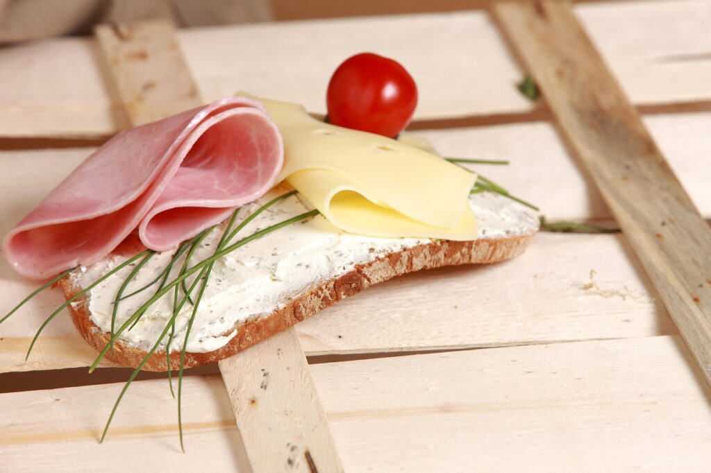 Hands assembling open-faced sandwich during a smorrebrod workshop