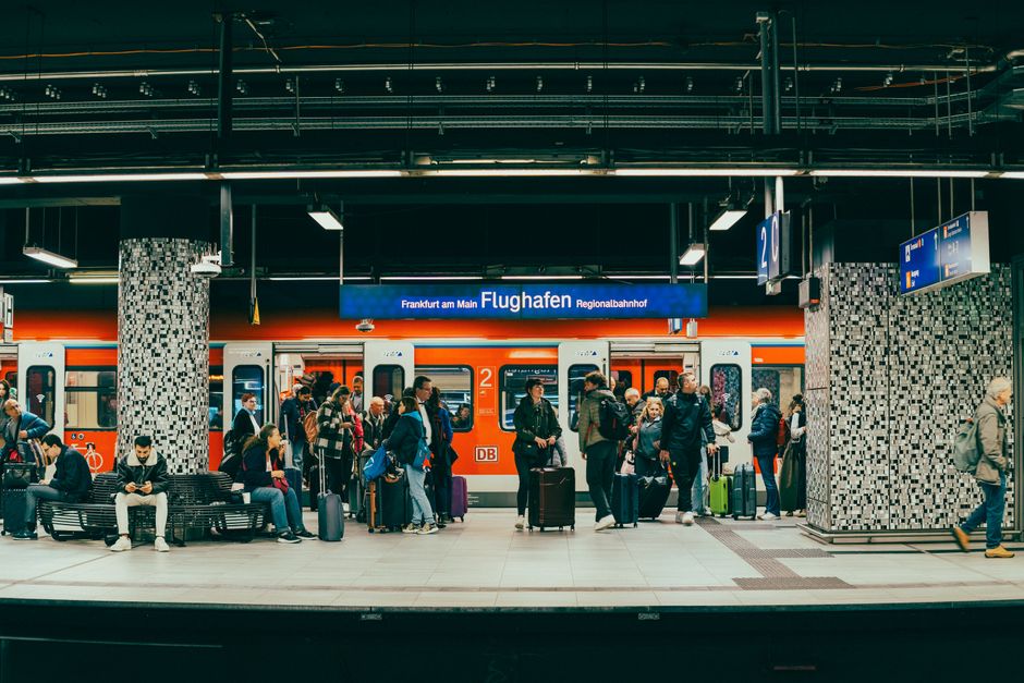 S-Bahn train arriving, passengers with luggage on platform