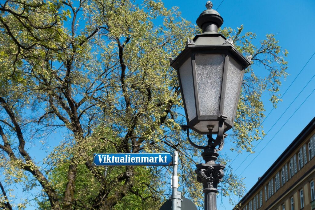 Munich tram passing by with Viktualienmarkt stall