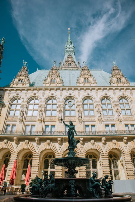 Person holding German residence permit card near the Rathaus