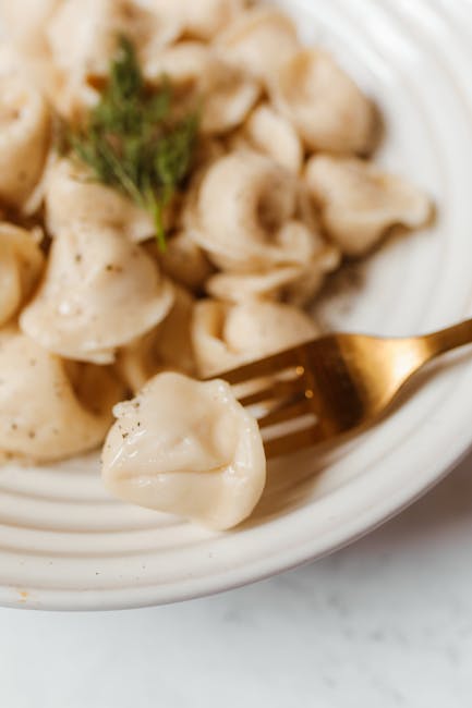 close-up van dampende pelmeni met zure room en dille
