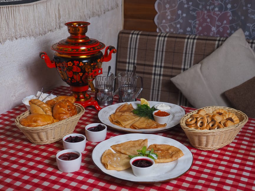 blini’s op een vintage bord met thee uit de samovar