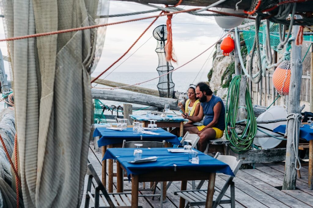 Mensen delen een schaal zeevruchten bij een restaurant aan zee