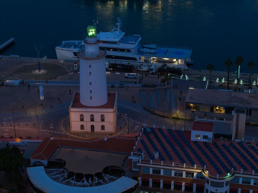Nighttime view of Málaga port restaurants lit up along the water
