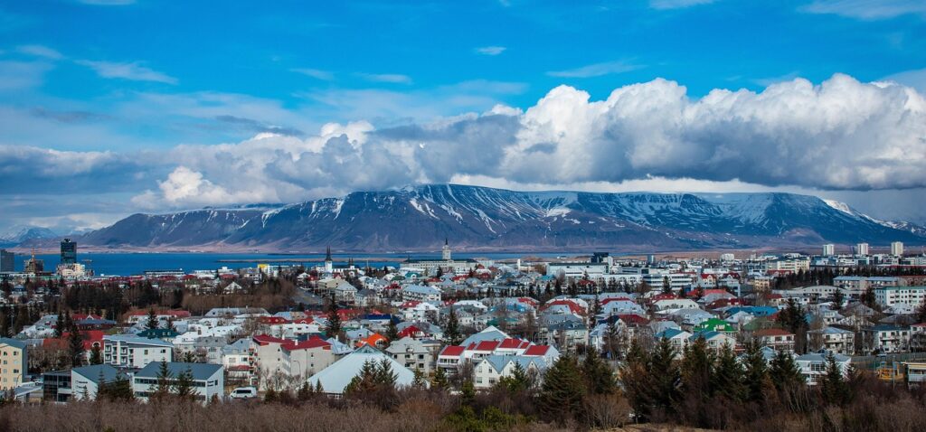 Haus mit Torfdach und Bergen im Hintergrund in Reykjavík