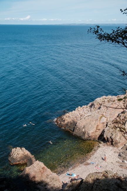 Plaża Huk na Bygdøy — kamieniste wybrzeże i kąpiący się ludzie