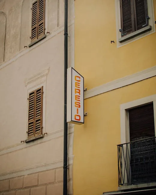 Enseigne verticale CERESIO fixée sur la façade jaune d'un immeuble