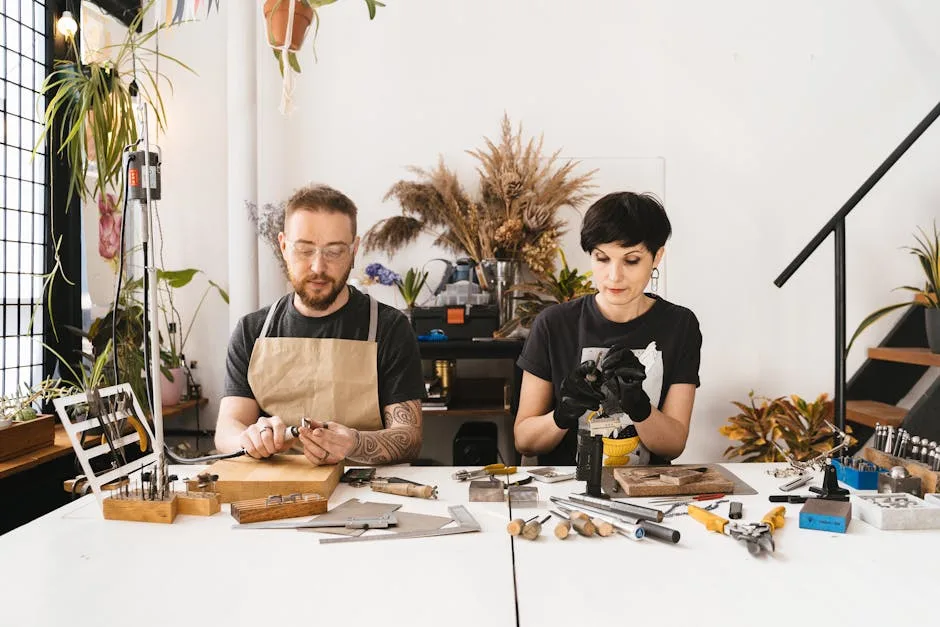 Deux artisans bijoutiers concentrés à un établi dans un atelier milanais