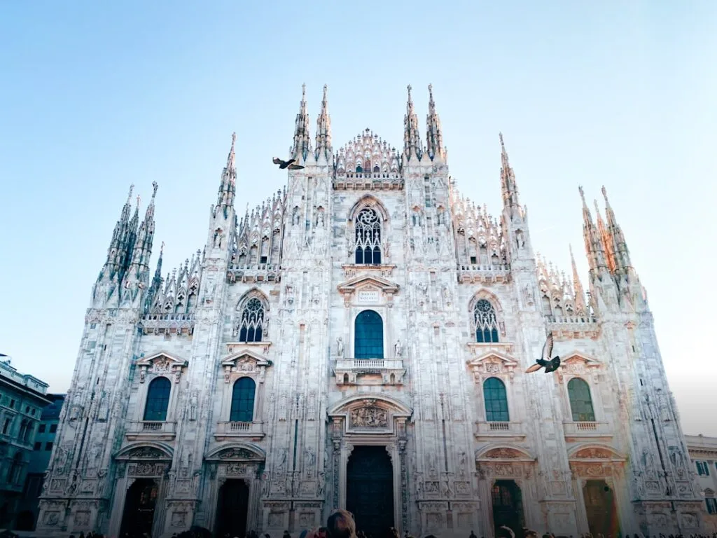 Façade du Duomo de Milan avec pigeons et ciel clair