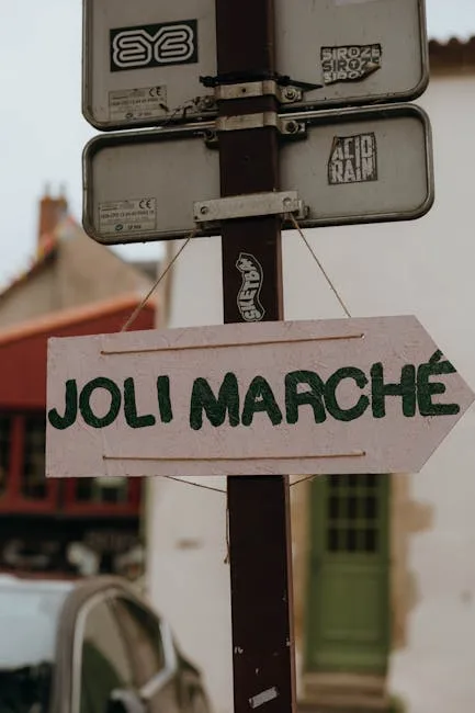 Panneau fléché en bois «JOLI MARCHÉ» accroché à un poteau.