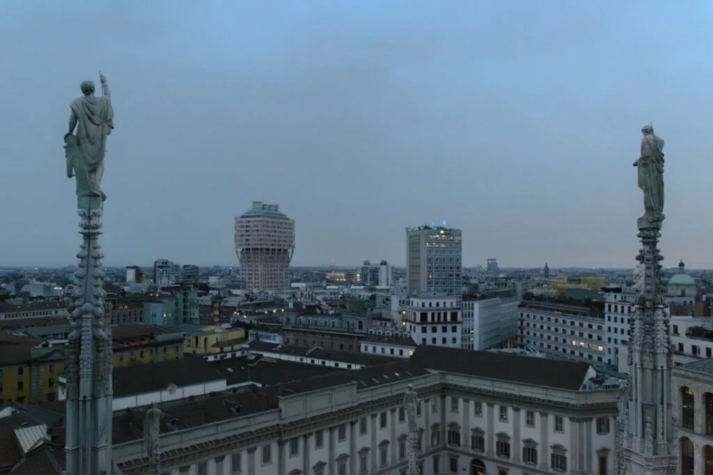 Statues sur les flèches du Duomo avec panorama urbain de Milan