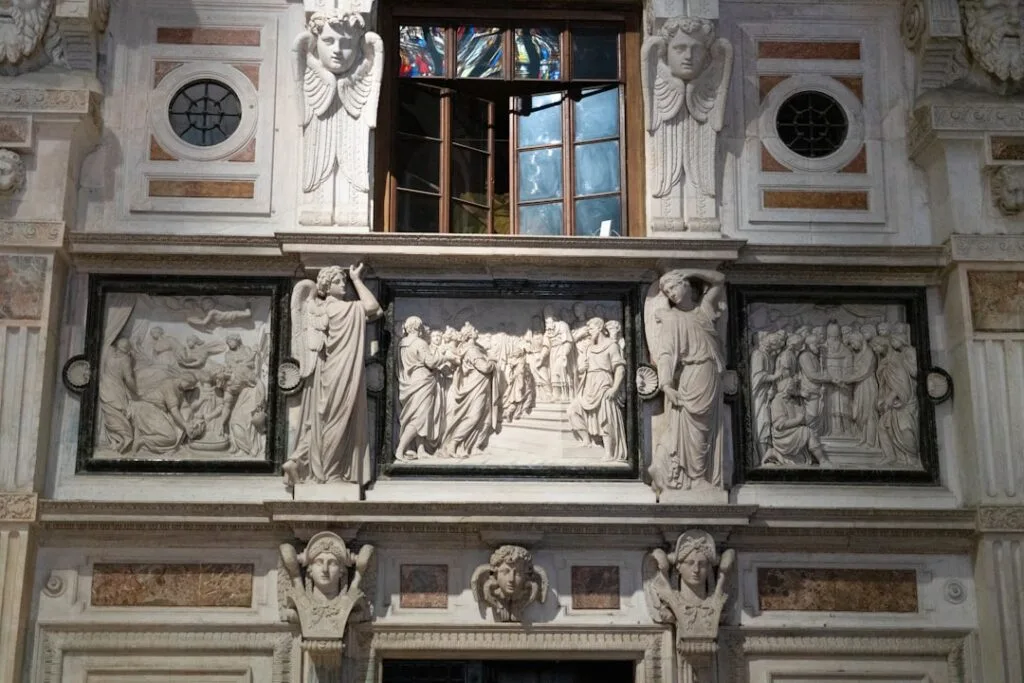 Bas-reliefs sculptés et fenêtres colorées dans une église de Bergame