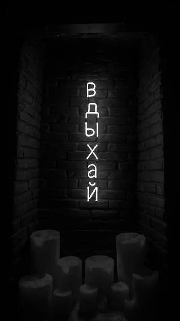 Enseigne néon cyrillique « Вдыхай » au-dessus de bougies