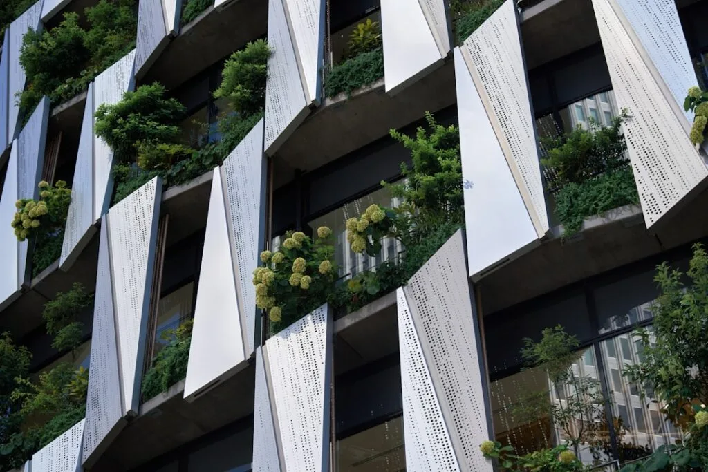 Moderne geperforeerde gevel in Milaan met witte panelen en begroeiing
