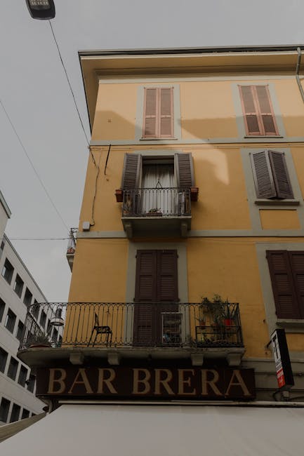 Facciata gialla con balcone e insegna Bar Brera nel quartiere Brera di Milano