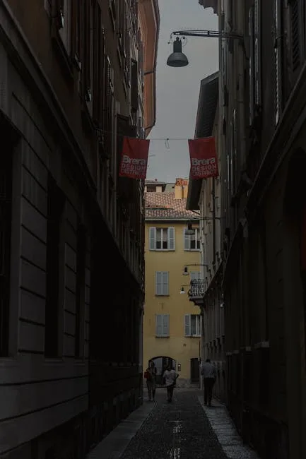 Ruelle étroite du quartier Brera à Milan, drapeaux 'Brera Design' visibles