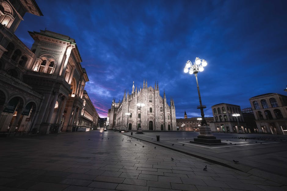 Der erleuchtete Mailänder Dom auf leerem Piazzetta bei blauem Abendhimmel