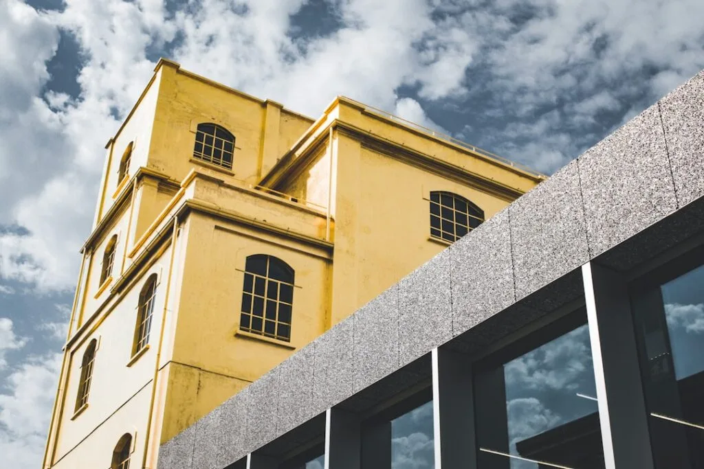 Bâtiment industriel jaune contrastant avec façade moderne à Milan