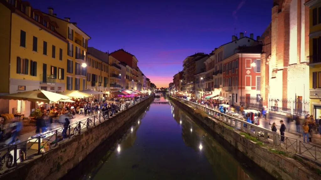 Canal des Navigli animé au crépuscule avec terrasses et reflets milanais
