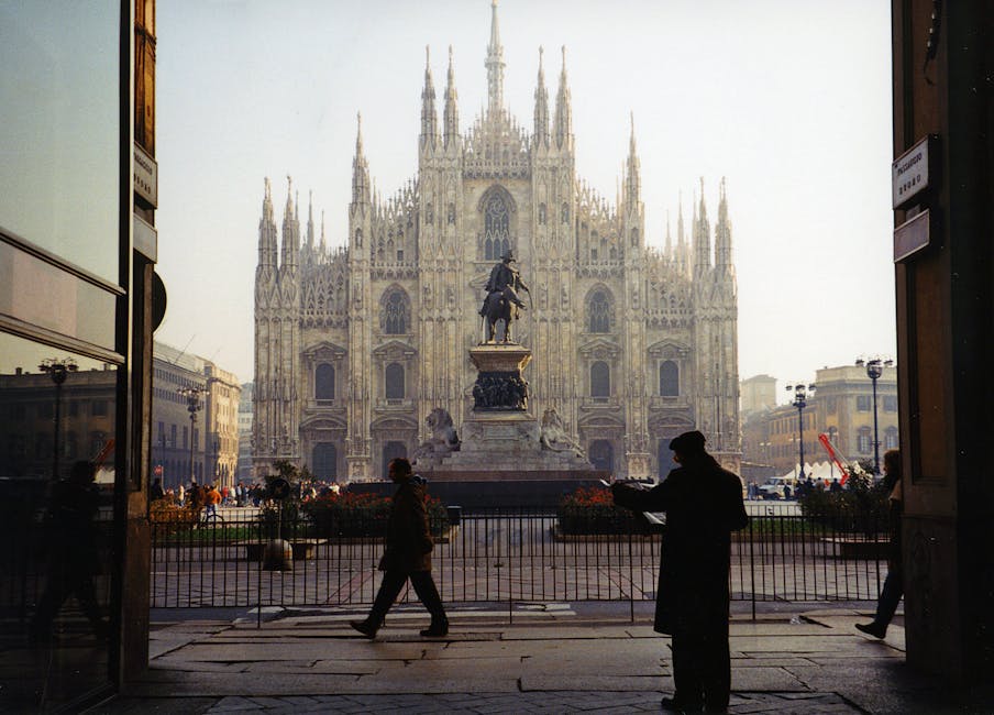 Vista del Duomo di Milano con statua e silhouette di passanti