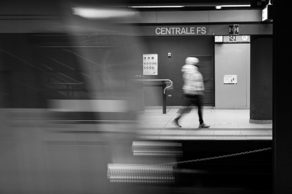 Verschwommener Zug und Person auf dem Bahnsteig Centrale FS in Mailand