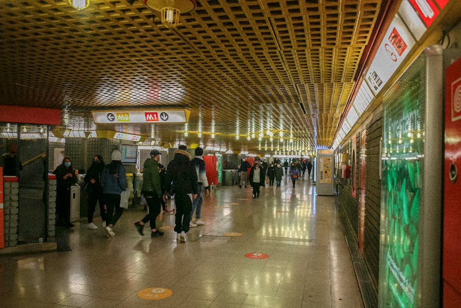 Belebte U-Bahn-Halle mit M1- und M3-Schildern in Mailand