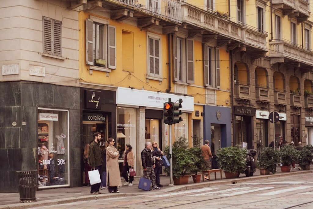 Passanten warten an Ampel vor Concept Stores in Mailand.