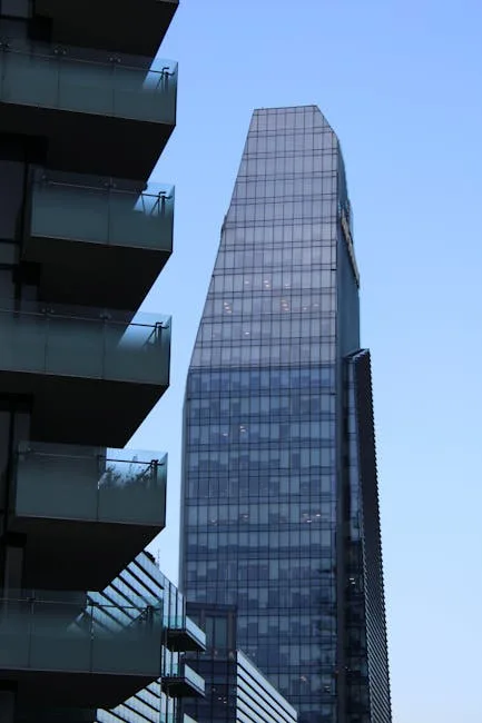 Glazen kantoortoren naast balkons bij schemerlicht in moderne wijk