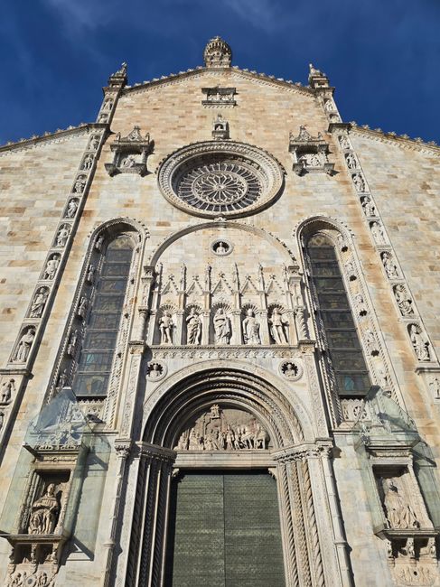 Fassadendetail des Doms von Como mit Rosettenfenster und steinernen Figuren