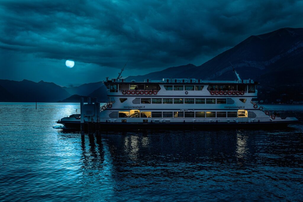 Fähre auf dem Comer See bei Nacht, Mondlicht und Bergsilhouette