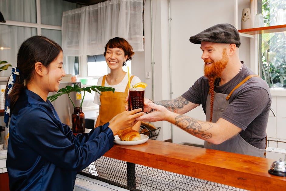 Kaffeerösterei‑Mitarbeiter begrüßt einen Kunden