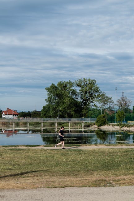 Morgendlicher Blick auf See und Spielplatz im Parc Titan mit Joggern