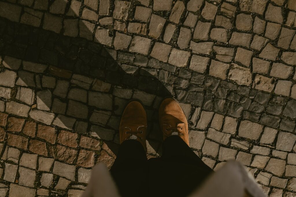 Touristen mit bequemen Schuhen erkunden eine Kopfsteinpflasterstraße