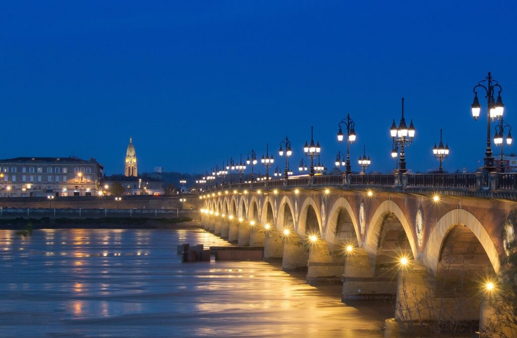 Avondzicht over de Garonne met verlichte brug in Bordeaux