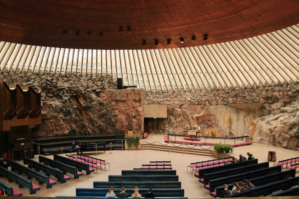 Interior of Temppeliaukio Church with rock walls and copper dome during a concert
