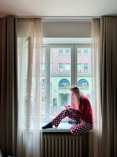Osoba sprawdzająca numery alarmowe na smartfonie w pokoju hotelowym w Helsinkach nocą