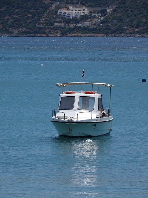 Boot voor anker bij Girolata met kleine vissersboten in de baai